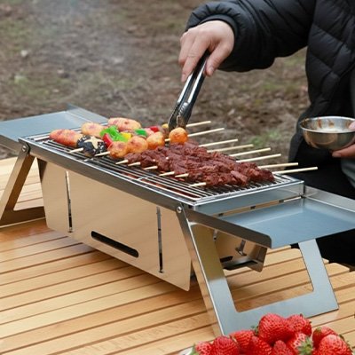 Barbecue charbon papa qui tourne les brochettes.