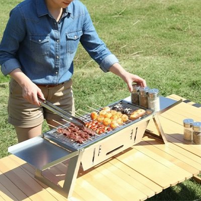 Barbecue charbon maman qui tourne les brochettes